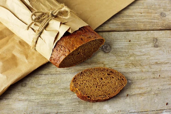 Τεμαχισμένο Καρβέλι Ψωμί Συσκευασμένο Χαρτί Ξύλινο Τραπέζι — Φωτογραφία Αρχείου