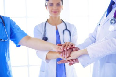 Doktorlar ellerini birleştiriyor. Yakın plan.