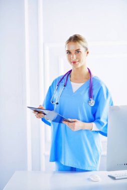 Üniformalı bir dosyayla gülümseyen kadın doktor.