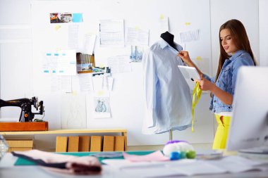 Çekici genç kadın yeni giysi koleksiyonu oluşturma sürecinde.