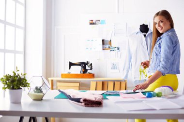 moda tasarımcısı olarak stüdyonun tasarımları üzerinde çalışıyor.