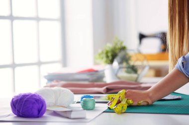 moda tasarımcısı olarak stüdyonun tasarımları üzerinde çalışıyor.