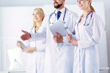 Meslektaşının önünde el sıkışan erkek doktor.
