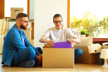 Mutlu genç çift açma veya kutu ambalaj ve yeni evine taşıdıktan.