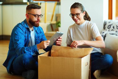 Yeni evlerinde karton kutuları açan sevimli bir çift..