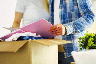 Yeni evli bir çift kutuları boşaltıyor ve yeni bir eve taşınıyor. Pozitif duygu.