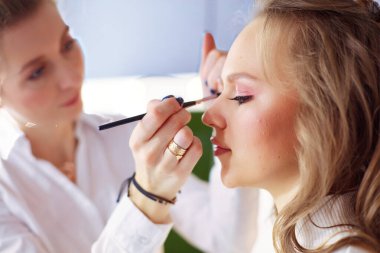 Güzel, genç bir model kadın makyaj yaptırıyor..