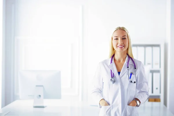 病院でノートパソコンを入力しながら仕事中の若い女性医師 — ストック写真