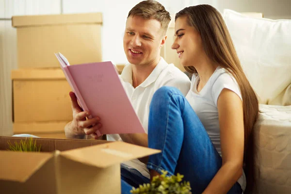 Young Couple Holding Album While Sitting Floor New House — Stock Photo, Image