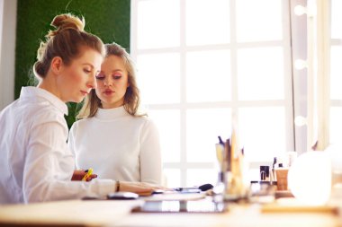 Güzel, genç bir model kadın makyaj yaptırıyor..