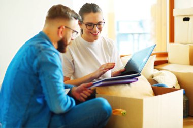 Yeni evlerinde karton kutuları açan sevimli bir çift..