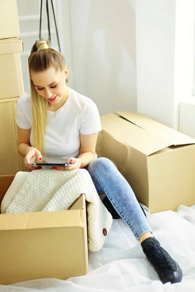 A beautiful single young woman unpacking boxes and moving into a new home.