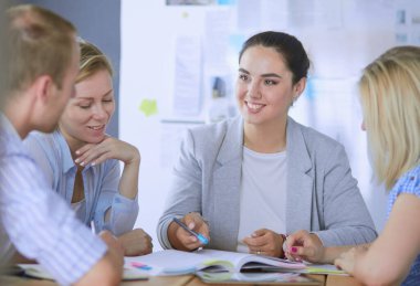 Masada kitaplarla çalışan gençler. Güzel kadınlar ve erkekler birlikte çalışıyor.