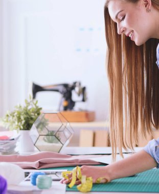 moda tasarımcısı olarak stüdyonun tasarımları üzerinde çalışıyor.