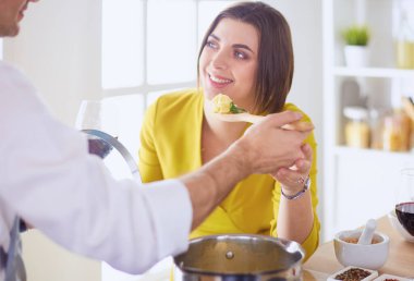 Evdeki mutfakta birlikte yemek pişiren çift..