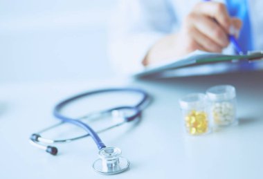 Kadınların elleri bir kağıt parçasına yazı yazıp masasında kalem bırakırlar..