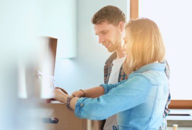 Genç bir çift yeni evde büyük karton kutu taşıyan. Ev taşıma. Genç Çift.