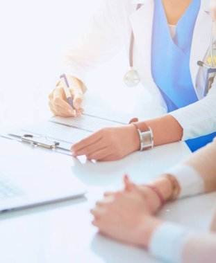 Doktor ve hasta çift masada oturmuş bir şey tartışıyorlar.