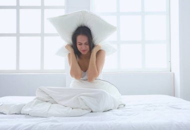 Onun baş ve kulaklar yastık ile kapsayan genç Kafkas kadın