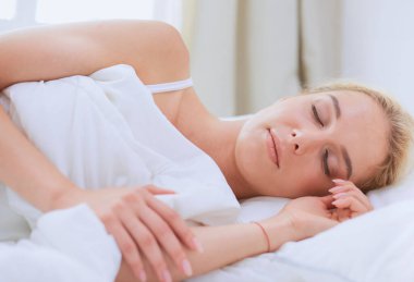 Güzel bir kadın yatağında uzanıyor..