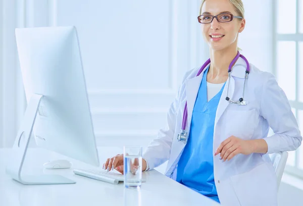 stock image Portrait of young female doctor sitting at desk in hospital.