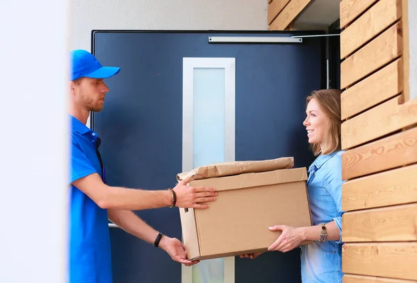 身穿蓝色制服的送货员向收件人 信使服务概念递送包裹箱 穿著蓝色制服的送货员 — 图库照片