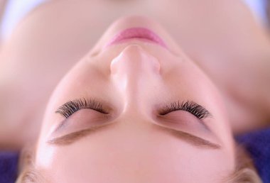 Masaj masasında uzanmış gözleri kapalı rahatlayan genç bir kadın. - Kadın. Spa salonu.
