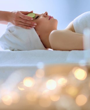 Masaj masasında uzanmış gözleri kapalı rahatlayan genç bir kadın. - Kadın. Spa salonu.