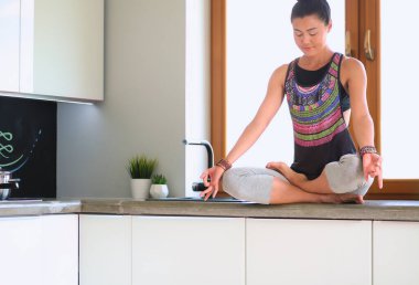 Formda ve çekici genç bir kadın sağlıklı yemek hazırlıyor. Kadın