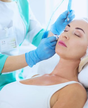 Kaşlar için kalıcı makyaj. Güzellik salonunda kalın kaşlı güzel bir kadın.