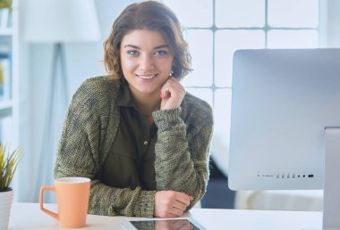 Öğrenci laptopla çalışıyor ve evdeki masada oturuyor..