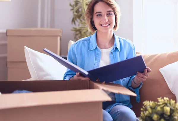 Young woman moving out and packing cardboard box.