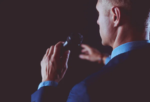 stock image Portrait of a businessman standing with a microphone and looking ahead, speak at the conference.