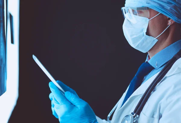 Arzt Krankenhaus Sitzt Schreibtisch Und Betrachtet Röntgenbilder Auf Tablet Vor — Stockfoto