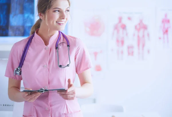 Sorridente Medico Donna Con Una Cartella Uniforme Piedi Ospedale — Foto Stock