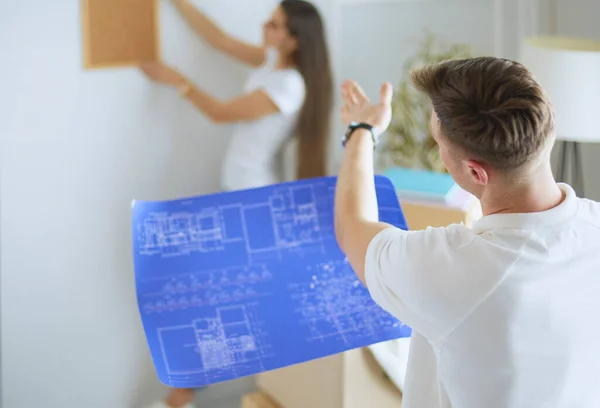 Женщина Помогает Своему Партнеру Повесить Картину Стену Нового Дома Обрамляет — стоковое фото