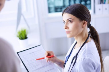 Güzel bayan doktor bir hastaya tıbbi tedaviyi açıklıyor.
