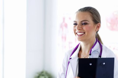 Üniformalı bir dosyayla gülümseyen kadın doktor.
