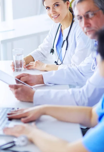 stock image Smiling doctor using a laptop working with her colleagues in a bright hospital room