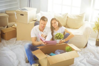 Mutlu genç çift açma veya kutu ambalaj ve yeni evine taşıdıktan.