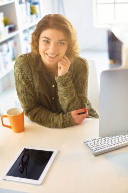 Çevrimiçi eğitim hizmetini kullanan güzel, gülümseyen kız öğrenci.