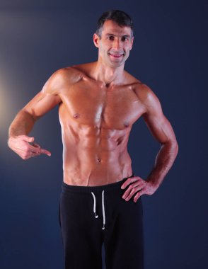 kaslı adam. Kaslı adam kas gösterilen gri arka plan üzerinde. Fitness Eğitmeni. Fitness profesyonel. Egzersiz. Mens fitness
