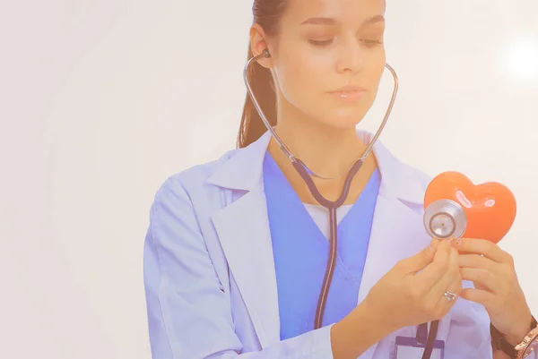 肯定的な女医が分離した聴診器と赤のハートマークと立っています 女性医師 — ストック写真