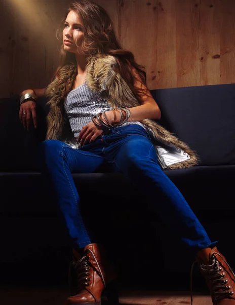Mavi Jeans Giydiği Siyah Kanepede Oturan Zarif Bir Kadın Portresi — Stok fotoğraf