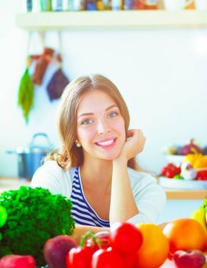 Mutfakta masanın yanında duran genç bir kadın. Genç kadın.