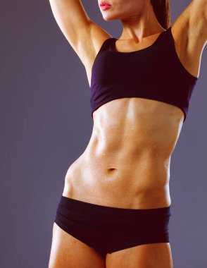 Gri arka plan üzerinde duran kas genç kadın. Kas genç kadın.