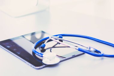 Tıbbi ekipman: Beyaz arka planda mavi steteskop ve tablet. Tıbbi ekipman.
