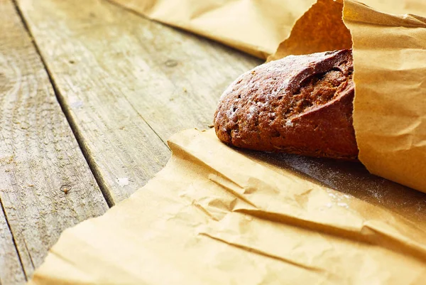Tahta Masanın Üzerinde Kağıda Sarılı Bir Somun Ekmek — Stok fotoğraf