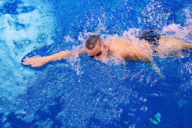 Yüzme havuzunda erkek yüzücü. Su altı fotoğrafı. Erkek yüzücü