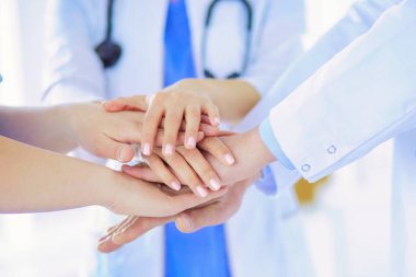 Doktorlar ellerini birleştiriyor. Yakın plan.